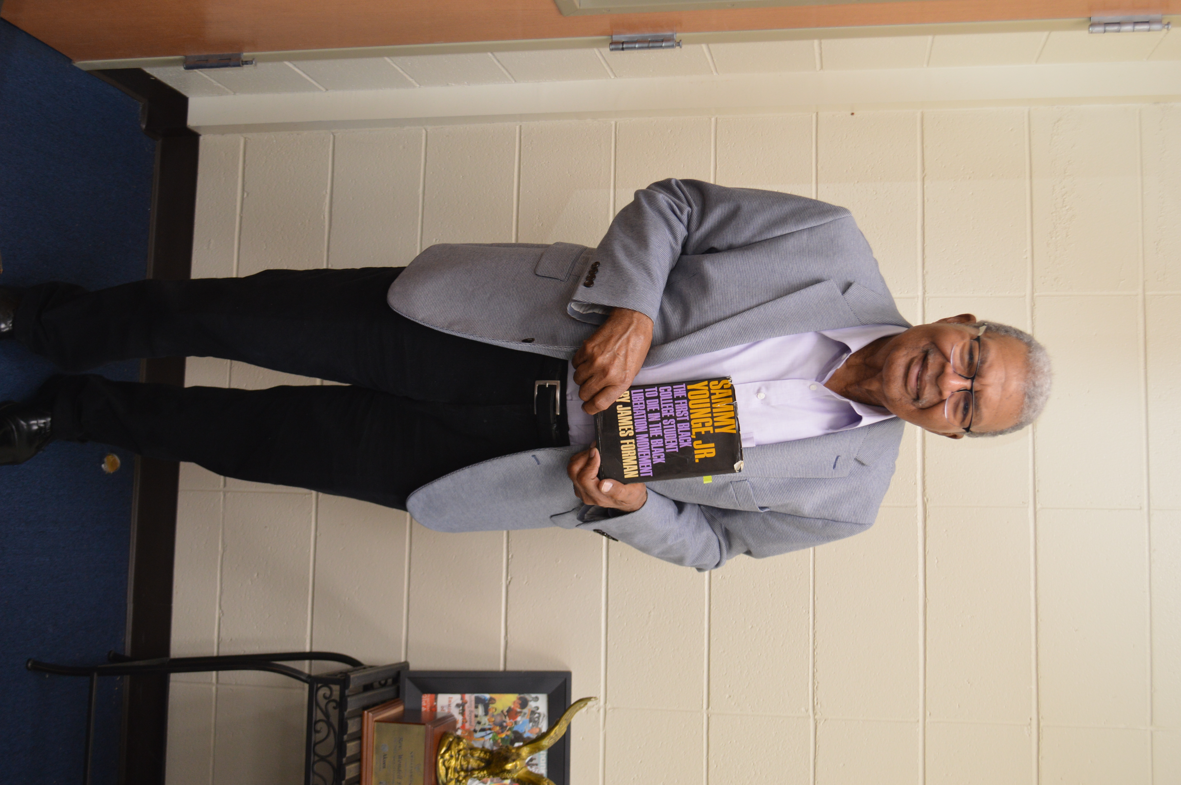 Revered Wendell Paris at New Hope Baptist Church in Jackson, Mississippi holding a copy of Sammy Younge Jr.: The First Black College Student to Die in the Black Liberation Movement. (Liz Ryan for APR)