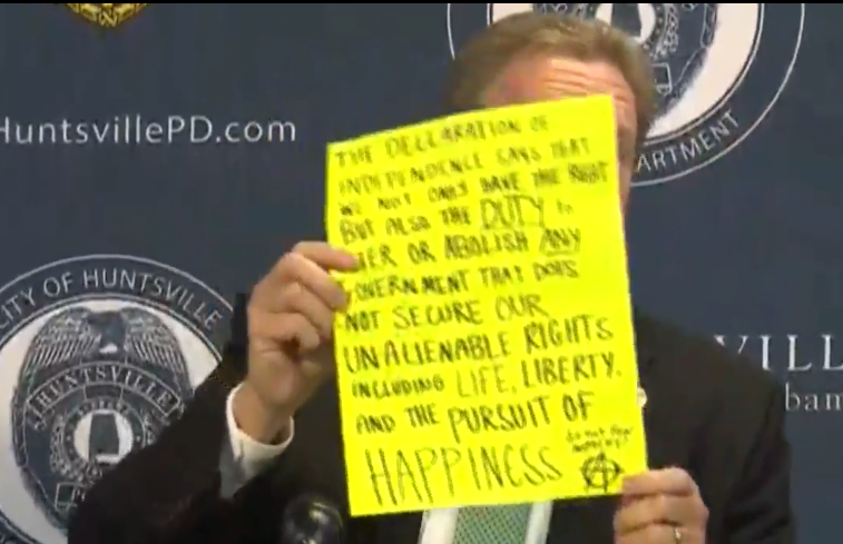 Huntsville's police chief holds up a poster a press conference that he claims to be from an Antifa group.